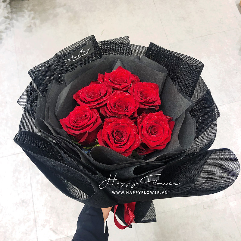 bó hoa hồng đỏ rực rỡ trên nền giấy gói đen